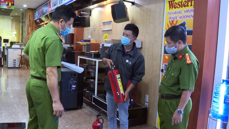 Lực lượng Công an hướng dẫn chủ cơ sở kết hợp nhà ở để kinh doanh sử dụng thiết bị chữa cháy. Ảnh: Lê Ánh