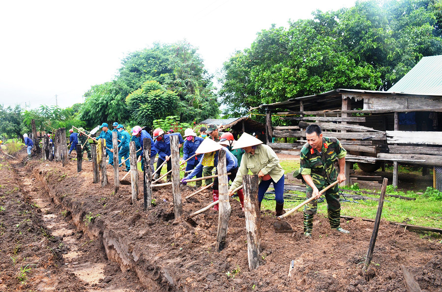  Cán bộ, chiến sĩ Trung đoàn Kinh tế-Quốc phòng 710 giúp người dân xã Ia Lâu (huyện Chư Prông) làm hàng rào. Ảnh: Vĩnh Hoàng