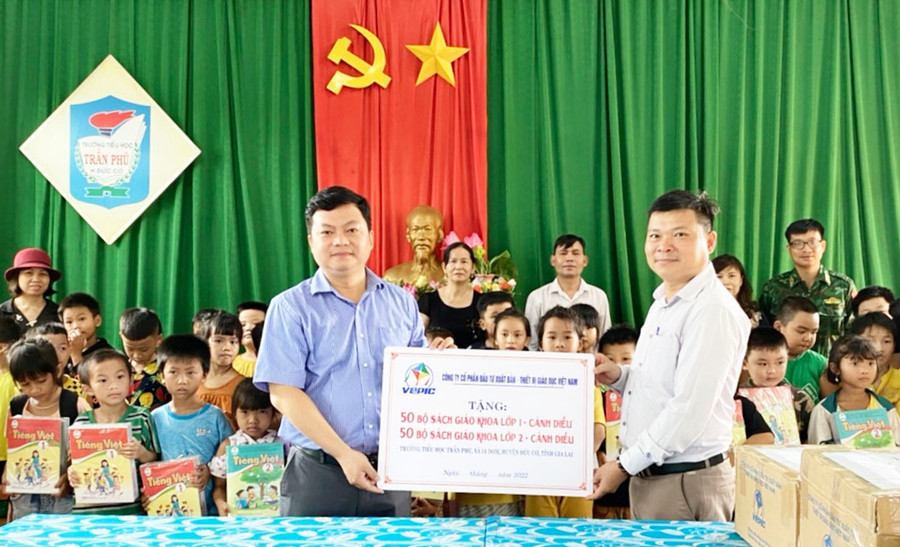  Đại diện Công ty cổ phần Đầu tư Xuất bản-Thiết bị giáo dục Việt Nam (bìa trái) trao tặng 100 bộ sách cho Ban Giám hiệu Trường Tiểu học Trần Phú (xã Ia Dom, huyện Đức Cơ). Ảnh: Lam Nguyên