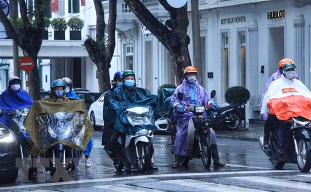 Mưa ảnh hưởng đến việc tham gia giao thông của người dân. (Ảnh: Tuấn Anh/TTXVN)