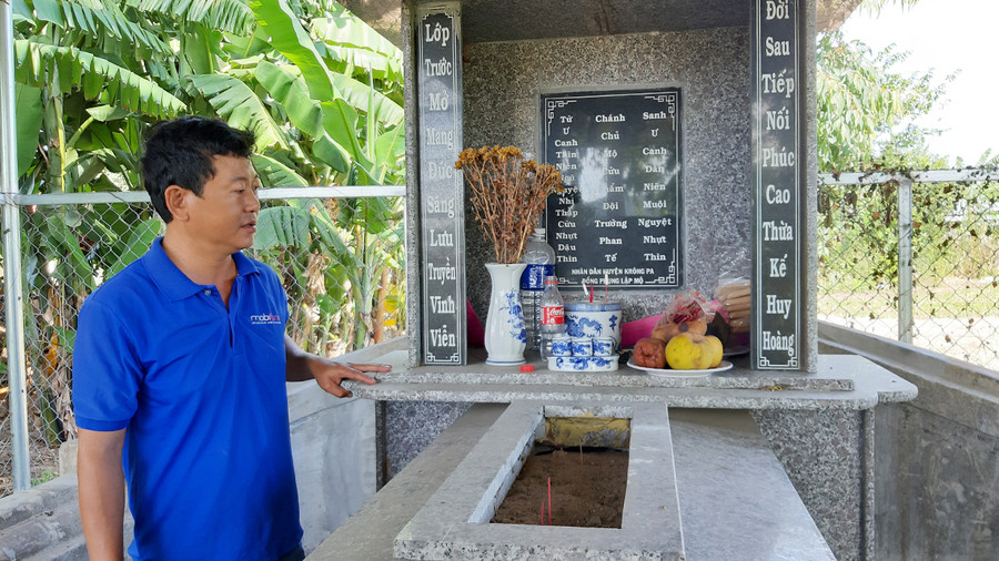 Ông Nguyễn Trung Thành-Trưởng thôn Thắng Lợi (xã Phú Cần, huyện Krông Pa) bên mộ vị tiền hiền họ Phan. Ảnh: Nguyễn Quang Tuệ