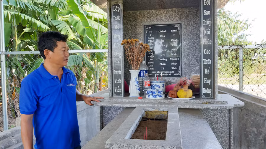 Ông Nguyễn Trung Thành-Trưởng thôn Thắng Lợi (xã Phú Cần, huyện Krông Pa) bên mộ vị tiền hiền họ Phan. Ảnh: Nguyễn Quang Tuệ