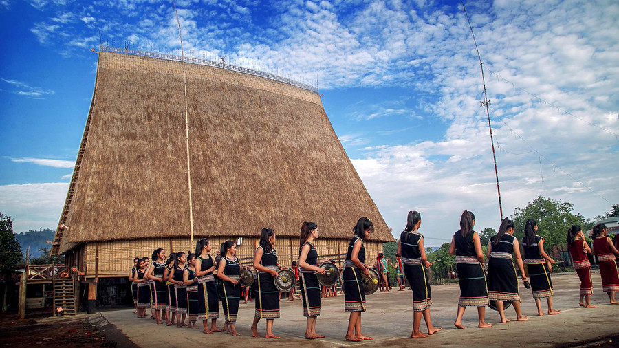 Đồng bào Tây Nguyên trình diễn cồng chiêng trước nhà rông của làng. Ảnh: N.L.V.Q