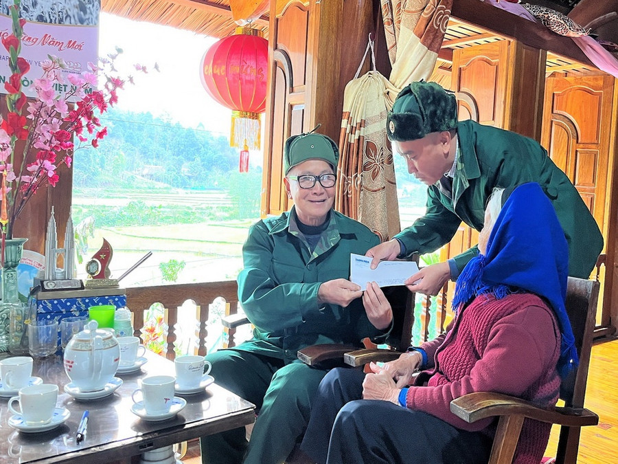 PV Báo Thanh Niên thăm, tặng quà cựu chiến binh - thượng tá Hoàng Văn Tựt (người ngồi bên trái) tại quê nhà ông đang nghỉ hưu (Ảnh chụp vào tháng 3.2022). Ảnh: Nông Quang Lập