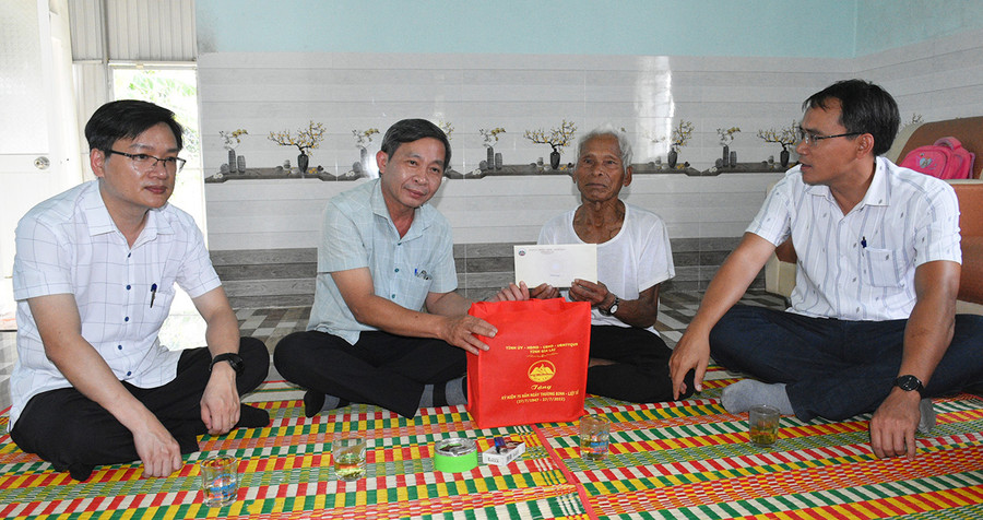 Trưởng Ban Tuyên giáo Huỳnh Thế Mạnh (thứ 2 từ trái qua) tặng quà ông Đinh Triêng- thương binh, làng Lợt, xã Kông Bơ La. Ảnh: Đinh Yến