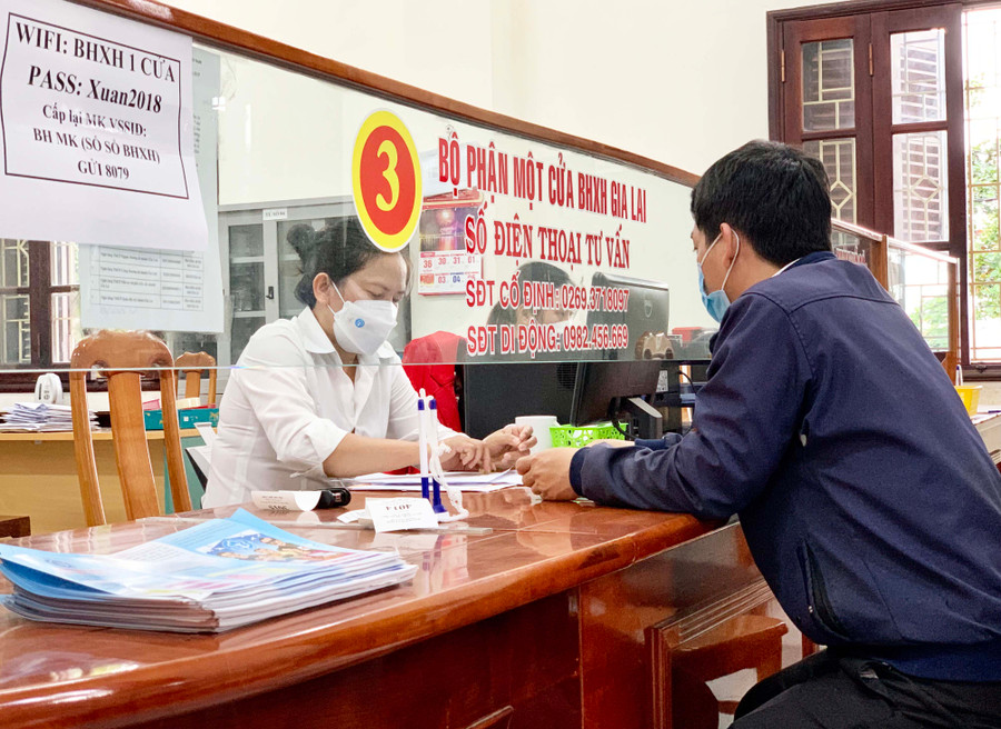 Cán bộ BHXH tỉnh hướng dẫn người dân các thủ tục liên quan chính sách BHXH, BHYT. Ảnh: Như Nguyện