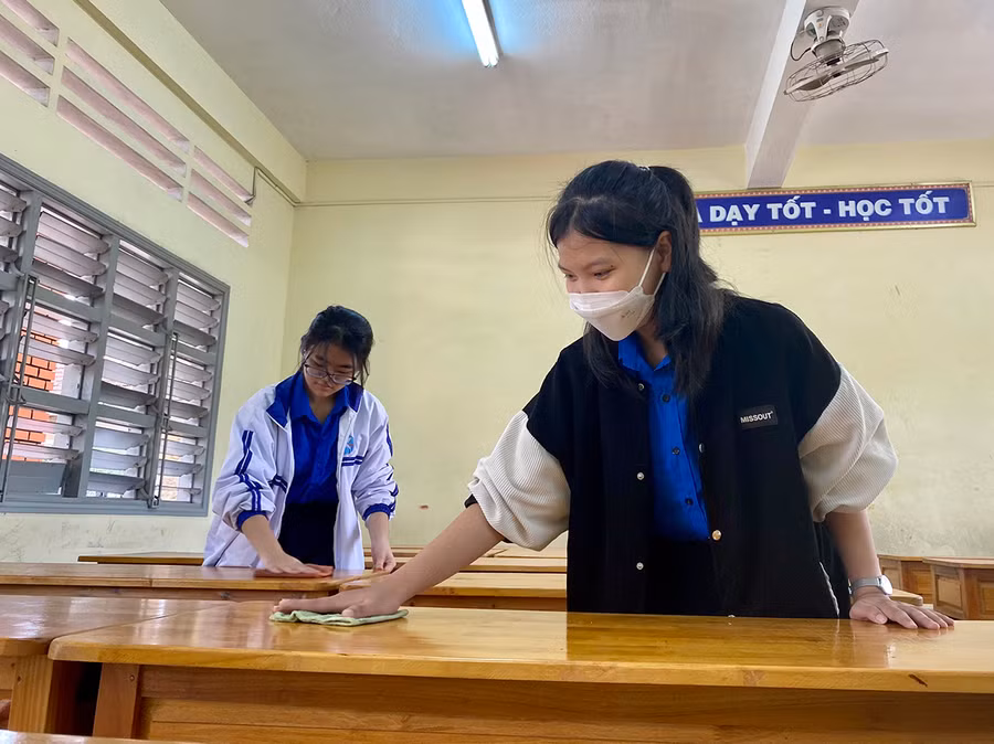 Học sinh Trường THPT Pleiku hỗ trợ dọn vệ sinh, khử khuẩn tại các phòng thi. Ảnh: Mộc Trà