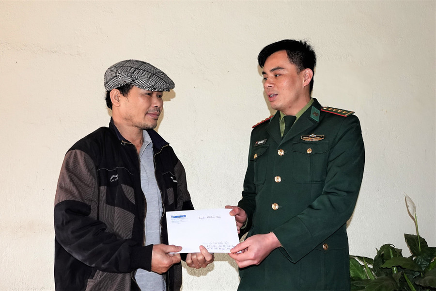 Cán bộ phòng Chính trị BĐBP Hà Giang tặng phần quà của bạn đọc Báo Thanh Niên tới cựu chiến binh La Văn Tuệ, nhân 75 năm ngày Thương binh - liệt sĩ. Ảnh: Mai Thanh Hải