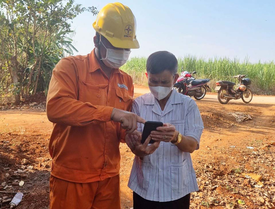 Nhân viên Điện lực hướng dẫn khách hàng sử dụng các tiện ích trên app CSKH của Tổng Công ty Điện lực miền Trung. Ảnh: Khang Nghi