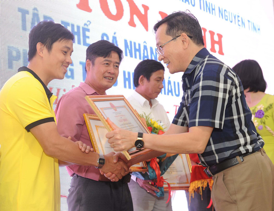 Anh Trần Vũ (bìa trái) được Sở Y tế tặng giấy khen vì thành tích vận động và tham gia hiến máu cứu người năm 2022. Ảnh: Hồng Thương