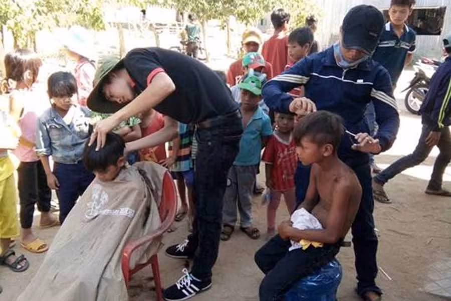 Cắt tóc miễn phí cho trẻ em trong làng. Ảnh: Hồng Thi
