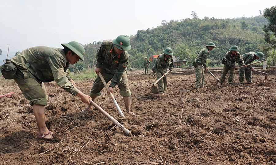 Cán bộ, chiến sĩ giúp dân khai hoang, phục hóa đất. Ảnh: V.H Cán bộ, chiến sĩ giúp dân khai hoang, phục hóa đất. Ảnh: V.H
