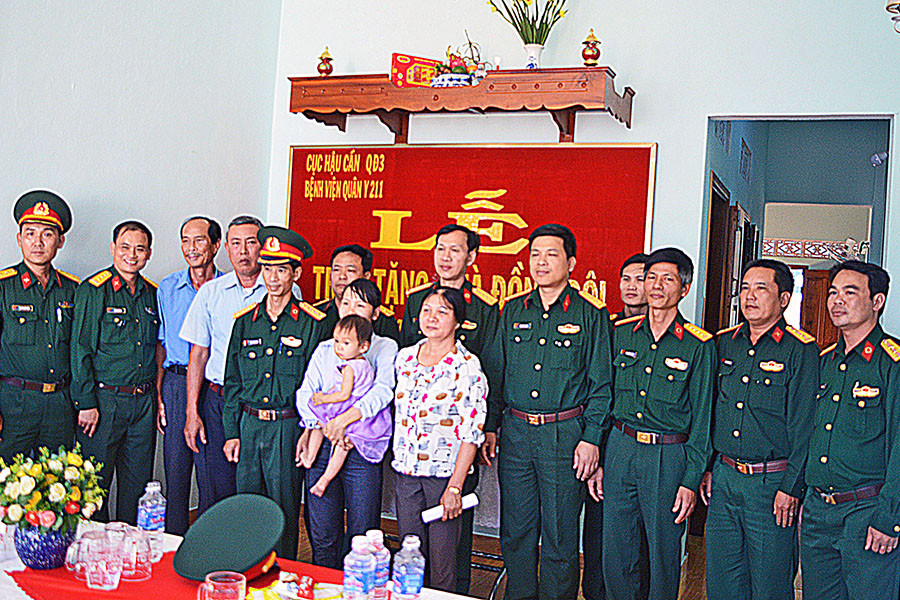  Đại diện lãnh đạo đơn vị, địa phương chụp ảnh lưu niệm với gia đình Trung úy QNCN Đặng Anh Phú. Ảnh: Sơn Tùng