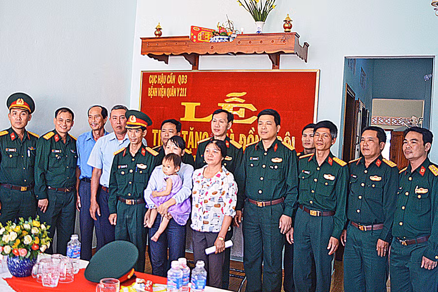  Đại diện lãnh đạo đơn vị, địa phương chụp ảnh lưu niệm với gia đình Trung úy QNCN Đặng Anh Phú. Ảnh: Sơn Tùng