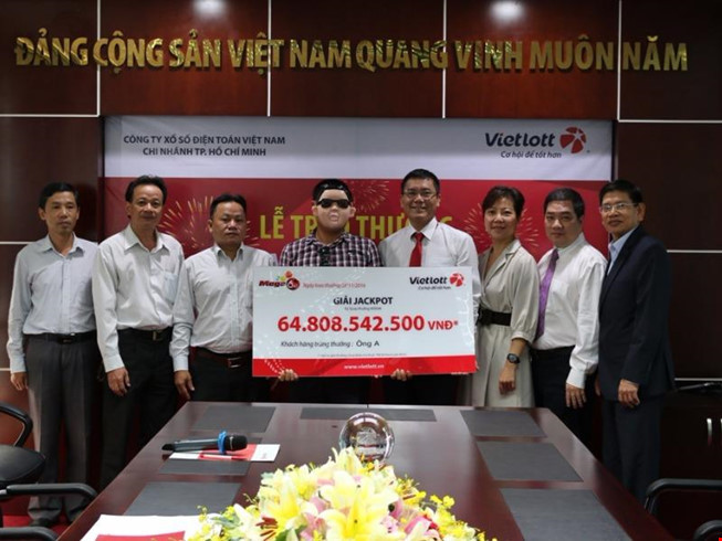 Người trúng thưởng Jackpot đeo mặt nạ khi nhận giải.