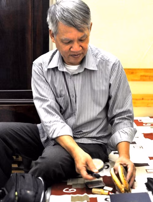 Ông Anh bên bộ đồ chuyên dùng để trang điểm cho người chết.