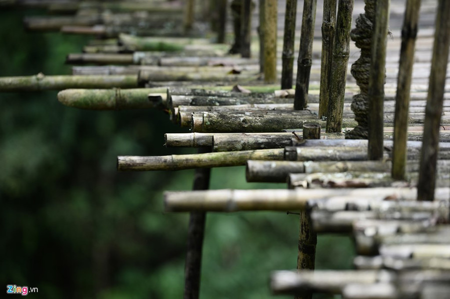 Hai chiếc cầu treo nối nhau vắt qua hai bên bờ suối dẫn vào làng đung đưa cót két dưới từng bước chân du khách. a