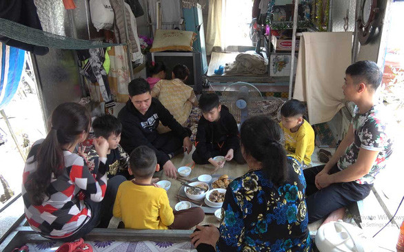 Gia đình bà Lê Thị Linh trong “tiệc” liên hoan nhỏ của con cháu dưới thuyền - Ảnh: TÂM LÊ