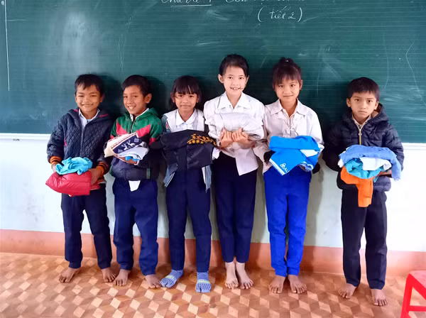 Các em học sinh của Trường Tiểu học Nguyễn Trãi (huyện Ia Grai) phấn khởi khi nhận được những bộ đồ do bà Dung và các Mạnh Thường Quân gửi tặng. Ảnh: M.T