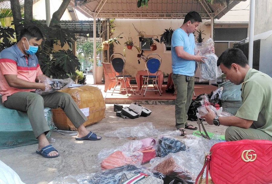 Lực lượng Quản lý Thị trường kiểm đếm số lượng túi xách giả mạo nhãn hiệu tại một cơ sở kinh doanh trực tuyến. Ảnh: V.T Lực lượng Quản lý Thị trường kiểm đếm số lượng túi xách giả mạo nhãn hiệu tại một cơ sở kinh doanh trực tuyến. Ảnh: V.T