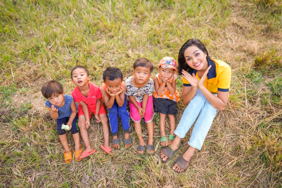 H'Hen Niê chụp hình với các em nhỏ trong bộ ảnh Tuổi thơ.