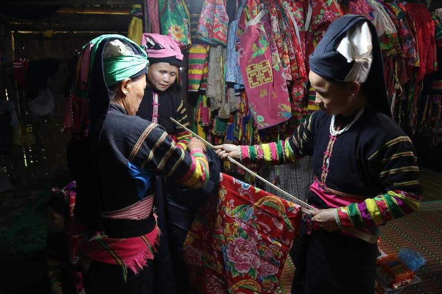 Người dân chuẩn bị vải để treo lên cây nêu trước sân nhà làm lễ. Người dân chuẩn bị vải để treo lên cây nêu trước sân nhà làm lễ.