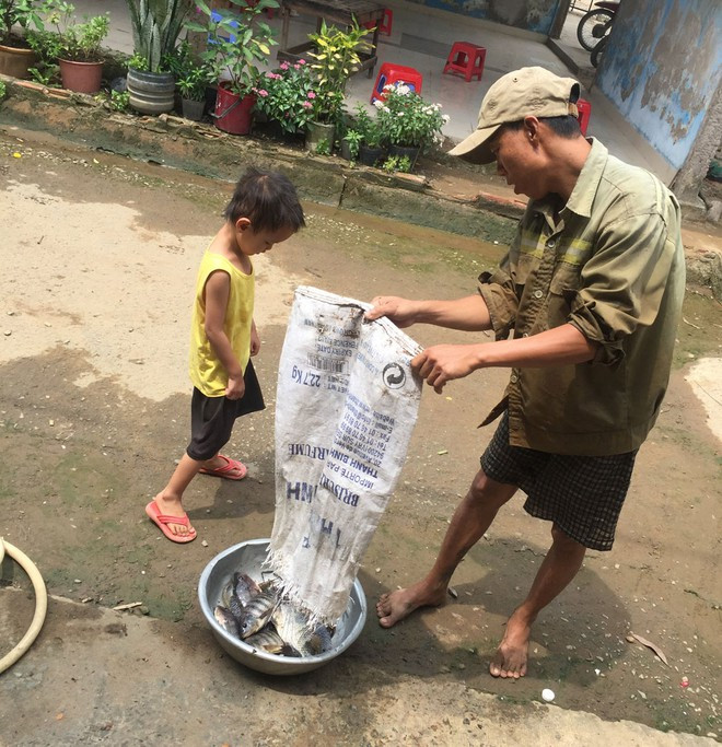 Anh Lê Văn Tiến tranh thủ bắt cá làm thức ăn cho bữa tối để tiết kiệm tiền sinh hoạt hằng ngày ẢNH: TRUNG DU