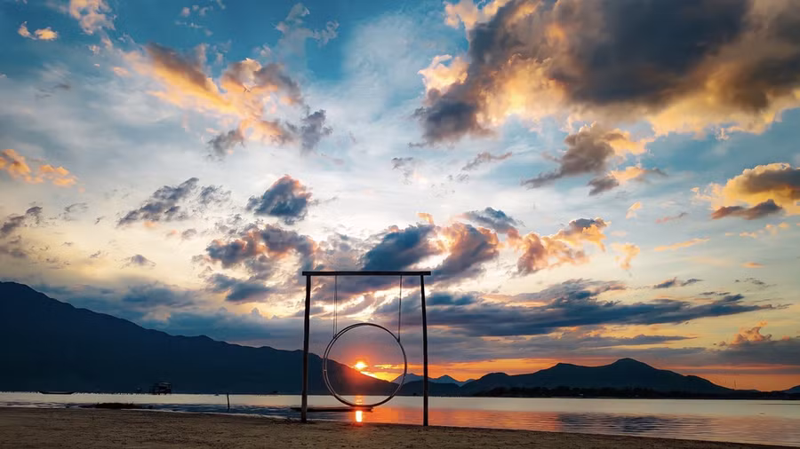 Nhóm bạn trẻ tạo dáng bên nhánh cây khẳng khiu và bè tre. Những dãy núi trùng điệp phía sau giúp khung cảnh thêm thi vị.