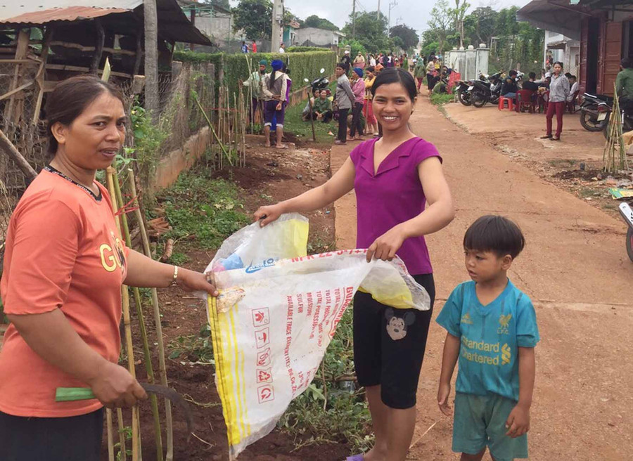 Hội viên làm bồn hoa trên đường làng Đê Ktu. Ảnh: Hà Phương