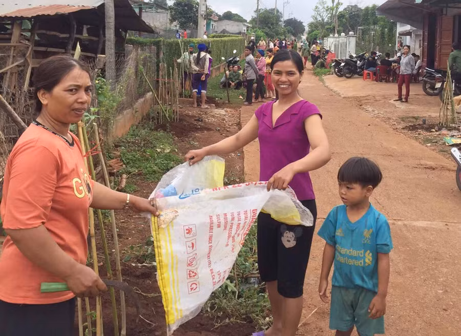 Hội viên làm bồn hoa trên đường làng Đê Ktu. Ảnh: Hà Phương