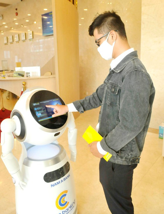 Sử dụng robot thực hiện giao dịch tại Ngân hàng TMCP Nam Á. Ảnh: CAO THĂNG Sử dụng robot thực hiện giao dịch tại Ngân hàng TMCP Nam Á. Ảnh: CAO THĂNG