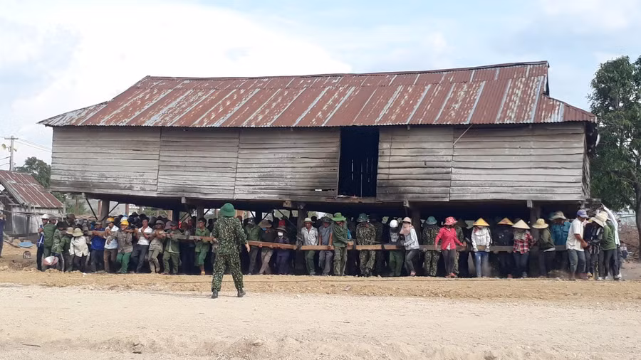  Bộ đội và dân làng Kinh Pêng di dời nhà cửa. Ảnh: Nguyễn Tú