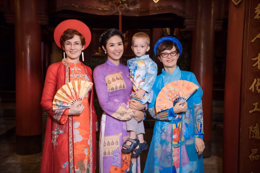 Trình diễn thời trang trong bộ sưu tập áo dài của Ngọc Hân còn có bà Paola Belfiore - Phu nhân đại sứ Italy tại Việt Nam (áo dài xanh), bà Nataliya Zhynkina - Đại biện lâm thời Đại sứ Ukraine tại Việt Nam (áo dài đỏ). Ảnh: Vũ Toàn. 