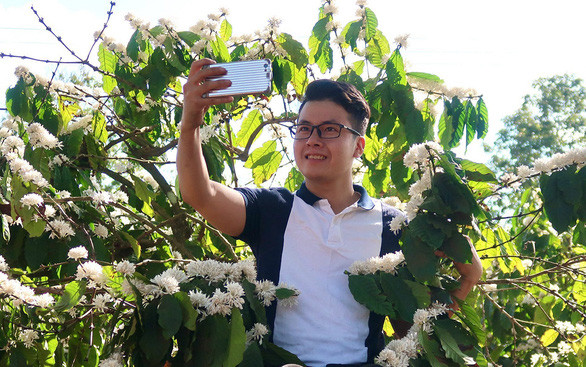 Phan Vũ Minh thích thú chụp ảnh hoa cà phê trong chuyến đi phượt lên Tây Nguyên tháng 3-2020 - Ảnh: V.P.