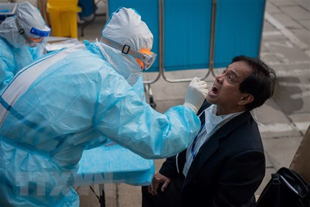 Nhân viên y tế lấy mẫu xét nghiệm COVID-19 cho người dân tại Bắc Kinh, Trung Quốc. (Ảnh: AFP/TTXVN) Nhân viên y tế lấy mẫu xét nghiệm COVID-19 cho người dân tại Bắc Kinh, Trung Quốc. (Ảnh: AFP/TTXVN)