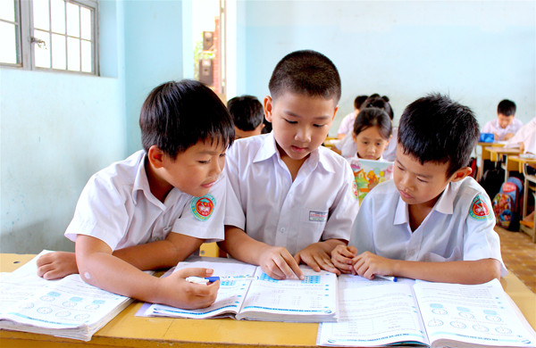 Em Ngô Hải Long (ở giữa; lớp 2/1, Trường Tiểu học Lương Thạnh, TP. Pleiku) thường xuyên giúp đỡ các bạn trong học tập. Ảnh: M.T 