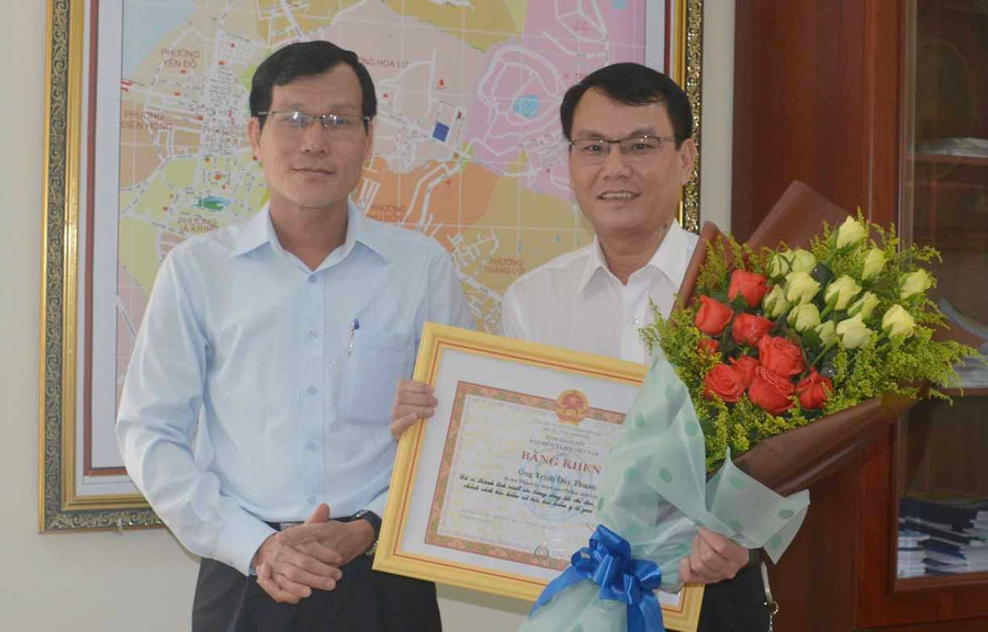 Thừa ủy quyền của Tổng Giám đốc BHXH Việt Nam, ông Trần Văn Lực- Giám đốc BHXH Gia Lai trao bằng khen cho Ủy viên Ban Thường vụ Tỉnh ủy, Bí thư Thành ủy Pleiku Trịnh Duy Thuân. Ảnh: Như Nguyện