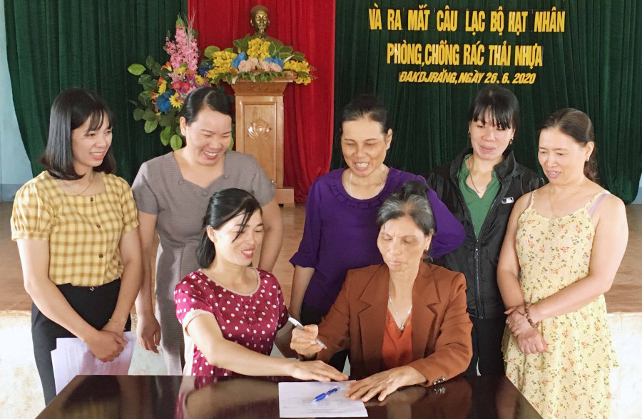 Các thành viên câu lạc bộ “Hạt nhân phòng, chống rác thải nhựa” ký cam kết thực hiện nội dung quy chế. Ảnh: Phạm Ngọc