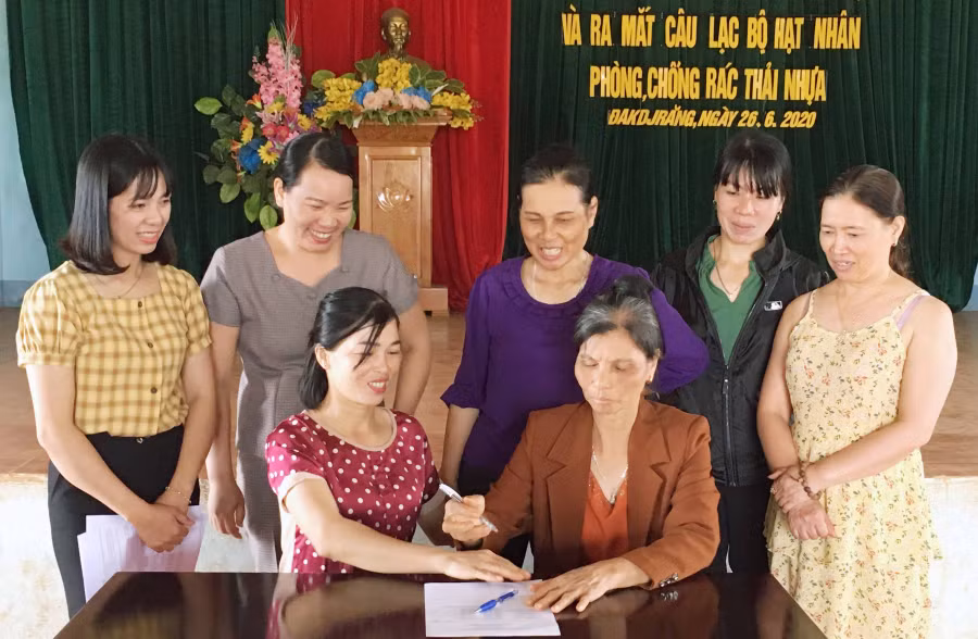 Các thành viên câu lạc bộ “Hạt nhân phòng, chống rác thải nhựa” ký cam kết thực hiện nội dung quy chế. Ảnh: Phạm Ngọc