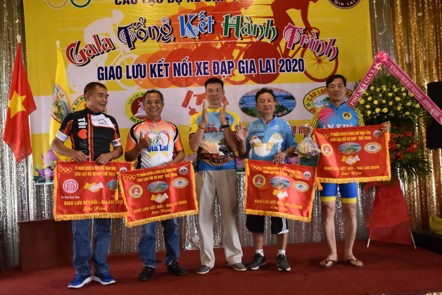 Ông Nguyễn Công Sự-Chủ nhiệm Câu lạc bộ xe đạp Gia Lai trao cờ lưu niệm cho các đơn vị tham gia tại chương trình. Ảnh: Hà Phương