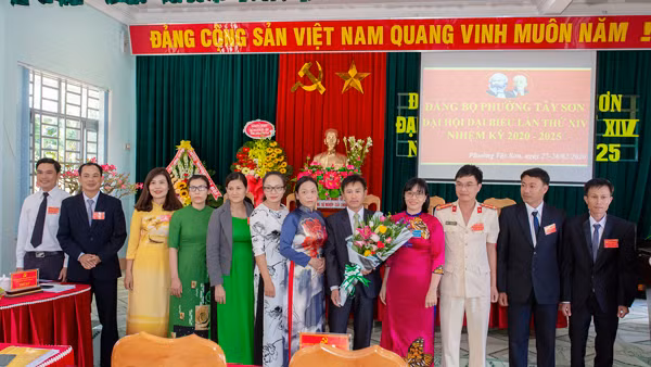 Bí thư Thị ủy An Khê Nguyễn Thị Thanh Lịch (thứ 4 từ phải sang) tặng hoa chúc mừng Ban Chấp hành Đảng bộ phường Tây Sơn. Ảnh: N.M