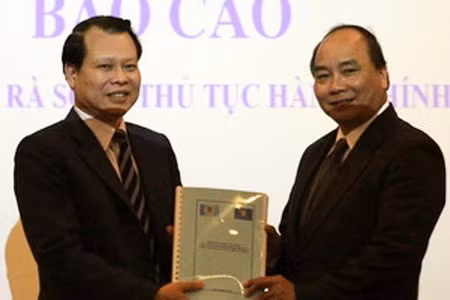 Bộ trưởng Bộ Tài chính Vũ Văn Ninh trao bộ thủ tục hành chính cho Bộ trưởng, Chủ nhiệm Văn phòng Chính phủ Nguyễn Xuân Phúc.