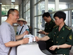 Nhân viên an ninh kiểm tra hành lý của hành khách nhập cảnh vào Việt Nam.