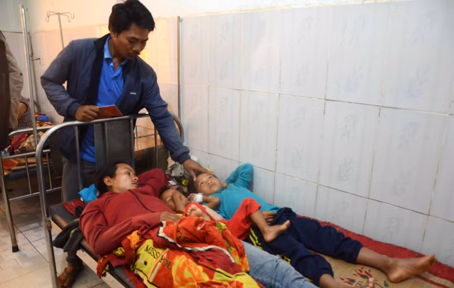 Anh Ksor Lim gia chủ bữa tiệc gây ngộ độc tập thể đang chăm sóc cho vợ và 2 con nhỏ bị ngộ độc được điều trị tại bệnh viện Phú Thiện. Ảnh: Đức Phương