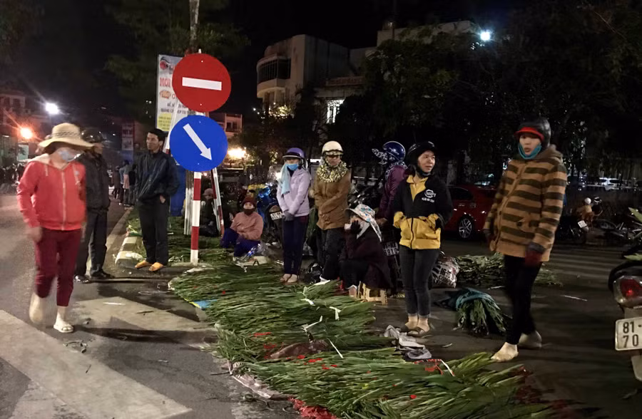 Những người phụ nữ bán hoa lay ơn co ro trong cái lạnh đêm Pleiku. Ảnh: Lê Hòa