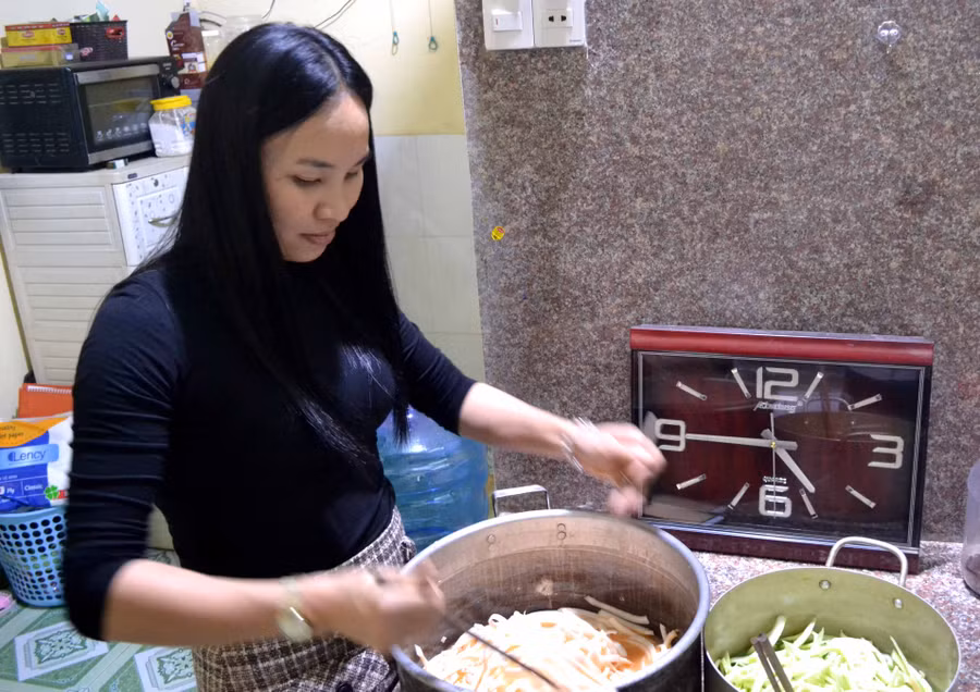 Chị Quỳnh nhuộm màu mứt dừa non từ nước ép cà rốt và lá dứa. Ảnh: Hải Lê Chị Quỳnh nhuộm màu mứt dừa non từ nước ép cà rốt và lá dứa. Ảnh: Hải Lê