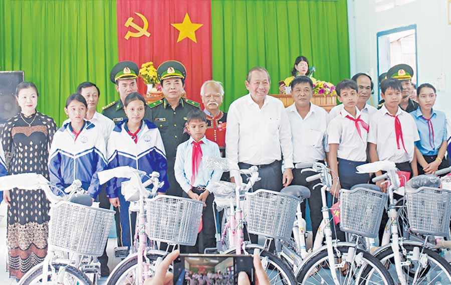 Phó Thủ tướng Thường trực Chính phủ Trương Hòa Bình (thứ 7 từ phải sang) tặng xe đạp cho học sinh khó khăn ở các xã Ia Dom, Ia Nan, Ia Pnôn (huyện Đức Cơ). Ảnh: M.T Phó Thủ tướng Thường trực Chính phủ Trương Hòa Bình