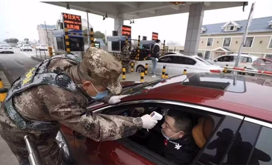 Kiểm tra thân nhiệt người dân ở Trung Quốc để phòng dịch bệnh viêm phổi cấp. Ảnh: South China Morning Post