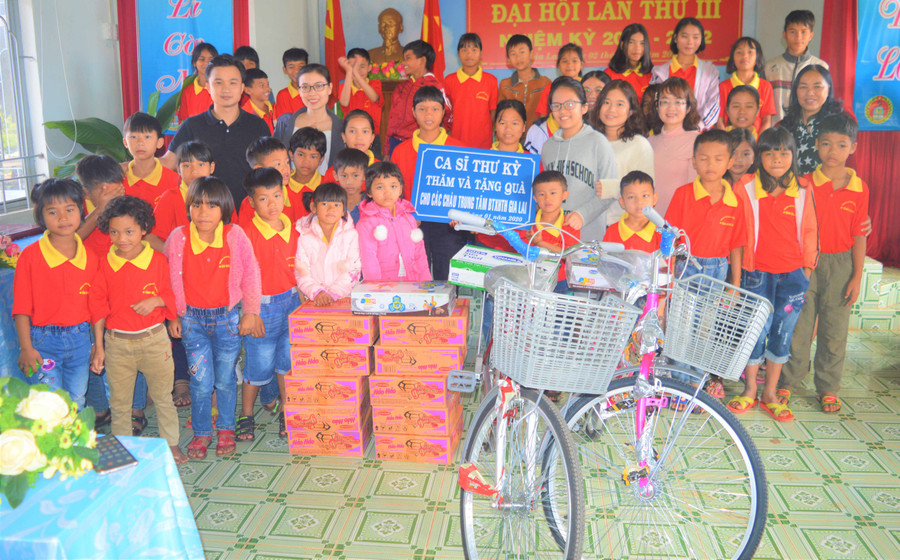  Ca sỹ Thư Kỳ (đeo kính đứng giữa) tặng quà, xe đạp cho các em mồ côi tại Trung tâm. Ảnh: Đinh Yến 