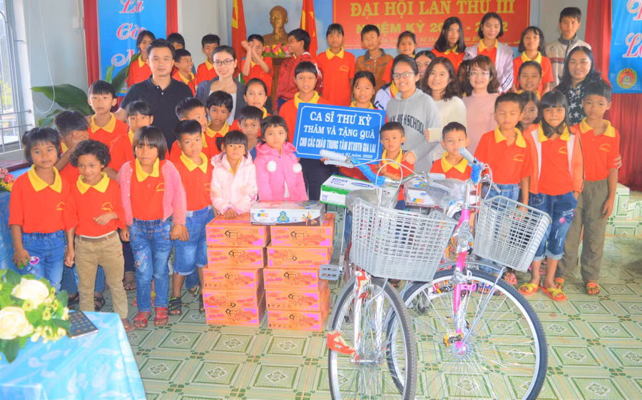  Ca sỹ Thư Kỳ (đeo kính đứng giữa) tặng quà, xe đạp cho các em mồ côi tại Trung tâm. Ảnh: Đinh Yến 